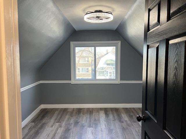 additional living space with hardwood / wood-style flooring and lofted ceiling