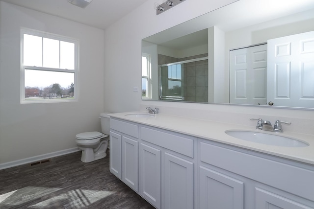 bathroom with vanity, toilet, a shower with door, and wood-type flooring