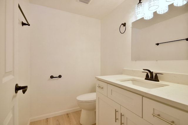 bathroom featuring vanity, hardwood / wood-style floors, and toilet