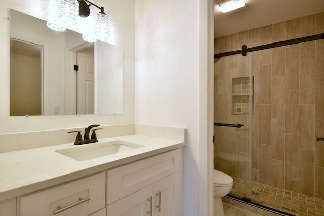 bathroom featuring vanity, toilet, and a shower with door