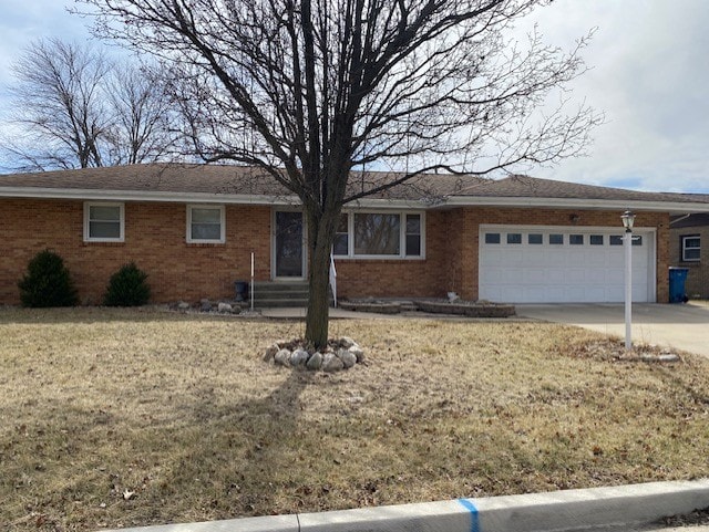 single story home with brick siding, an attached garage, and driveway