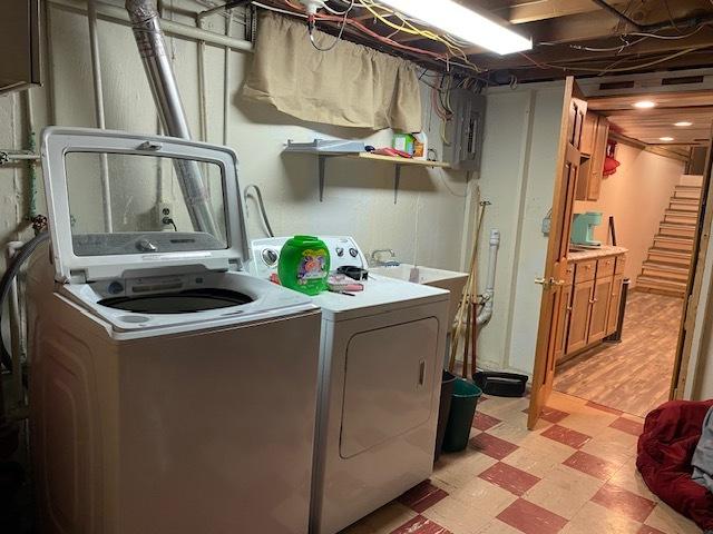 washroom featuring laundry area, washing machine and clothes dryer, and light floors