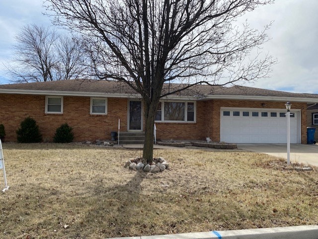 single story home featuring brick siding, driveway, and a garage