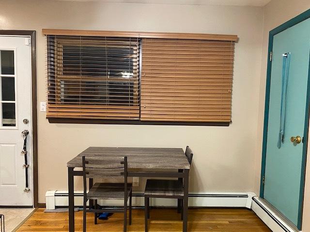 dining area with a baseboard radiator and wood finished floors