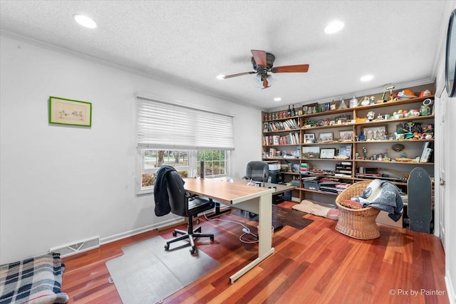 office with ceiling fan, wood-type flooring, ornamental molding, and a textured ceiling