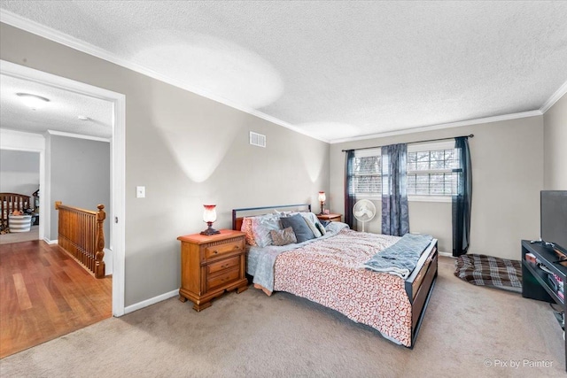 carpeted bedroom featuring ornamental molding and a textured ceiling