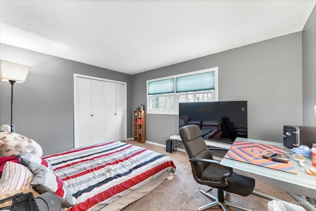 carpeted bedroom with a textured ceiling and a closet