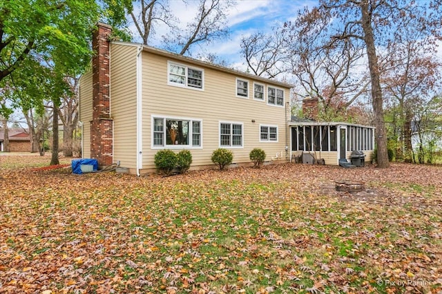 rear view of property featuring a sunroom