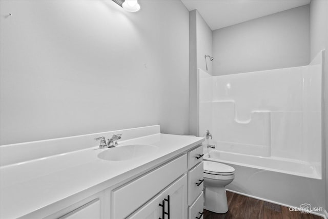 full bathroom featuring vanity, wood-type flooring,  shower combination, and toilet