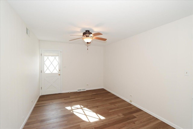 empty room featuring dark wood-type flooring and ceiling fan