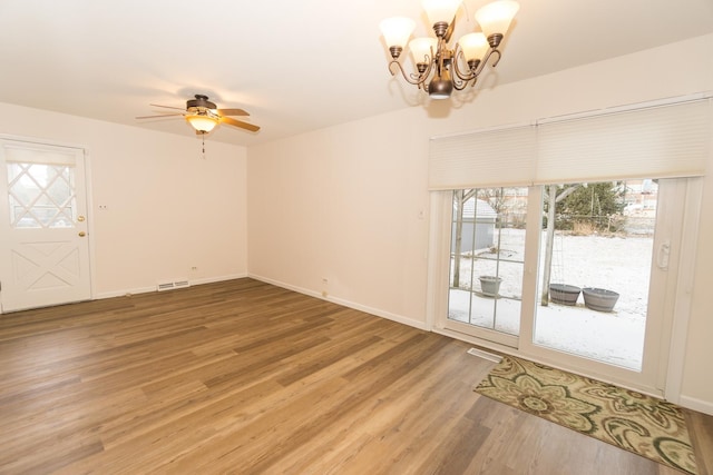 interior space with hardwood / wood-style flooring and ceiling fan with notable chandelier