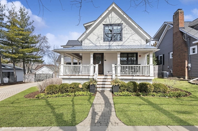 view of front facade featuring a front yard, a porch, cooling unit, and metal roof