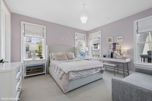 bedroom featuring a notable chandelier and light carpet