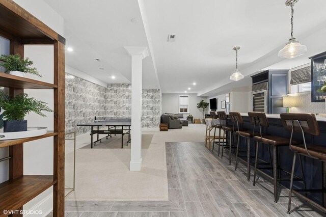 interior space featuring a community bar, recessed lighting, and decorative columns