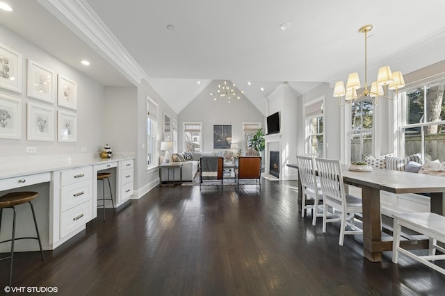 dining room with a notable chandelier, dark wood-style floors, a healthy amount of sunlight, and vaulted ceiling