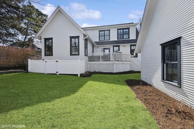 back of property featuring a deck and a yard