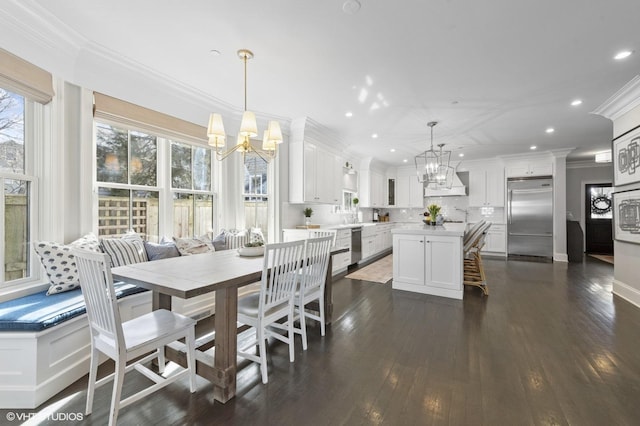 dining space featuring dark wood-style flooring, a chandelier, recessed lighting, and crown molding