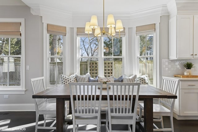 dining space with ornamental molding, baseboards, a chandelier, and dark wood finished floors