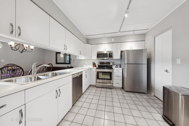 kitchen with rail lighting, sink, white cabinetry, light tile patterned floors, and stainless steel appliances