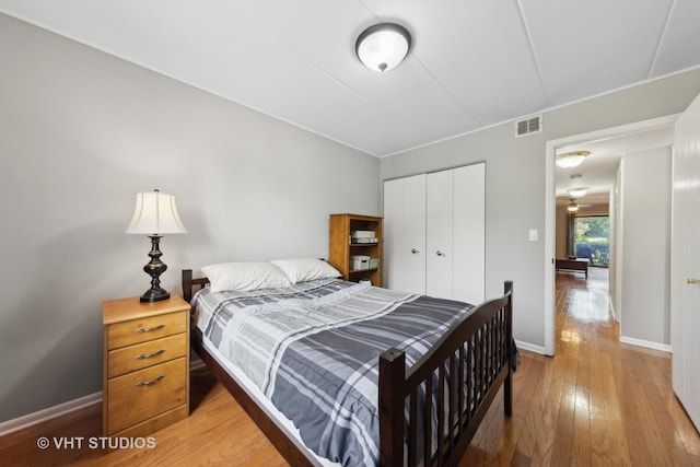 bedroom with light hardwood / wood-style floors and a closet