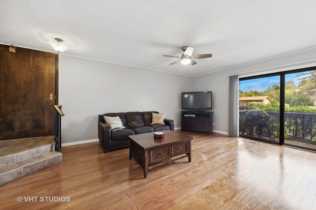 living room featuring ceiling fan and light hardwood / wood-style floors