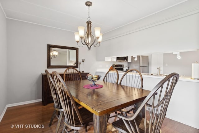 dining area featuring dark hardwood / wood-style flooring, a chandelier, and sink