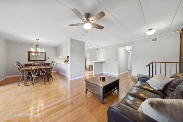 living room featuring ceiling fan with notable chandelier, track lighting, and light wood-type flooring