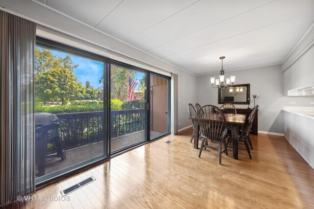 dining space featuring a wealth of natural light, a chandelier, and light hardwood / wood-style floors