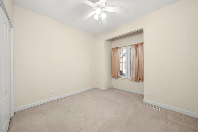 carpeted spare room with ceiling fan