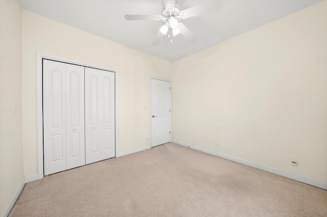 unfurnished bedroom with ceiling fan, light colored carpet, and a closet