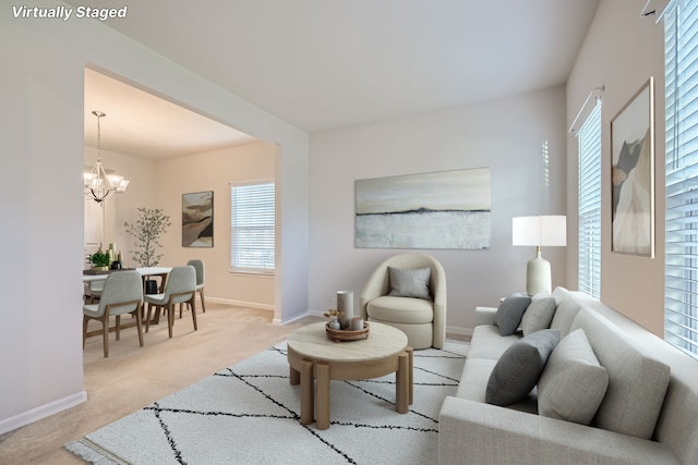 carpeted living room featuring plenty of natural light and an inviting chandelier