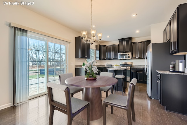 dining area with hardwood / wood-style flooring and a chandelier