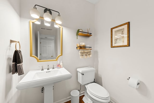 half bath with visible vents, toilet, and baseboards