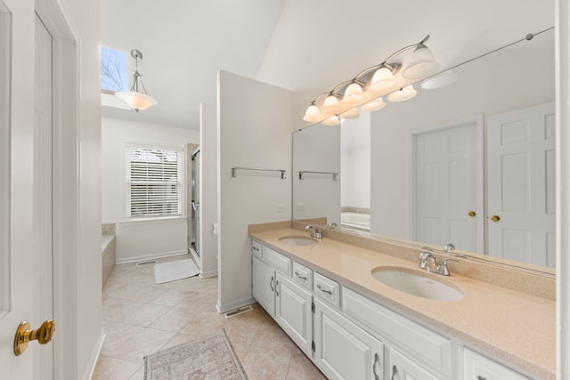 bathroom with tile patterned flooring, a sink, and a bath