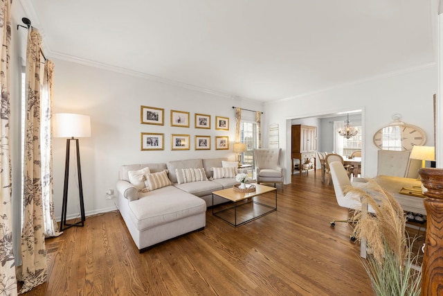 living room with crown molding, baseboards, wood finished floors, and an inviting chandelier