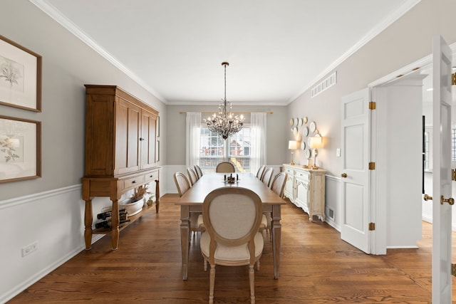 dining room featuring crown molding, dark wood-style flooring, and a notable chandelier