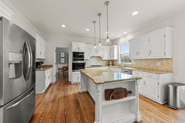 kitchen with a center island, open shelves, hanging light fixtures, appliances with stainless steel finishes, and white cabinetry