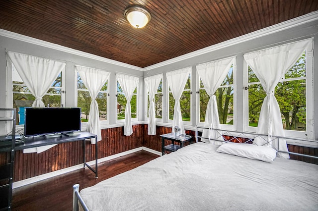 bedroom with ornamental molding, wood finished floors, and multiple windows