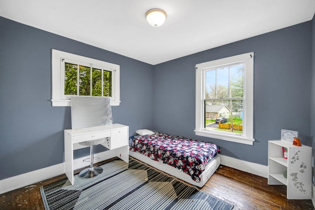 bedroom featuring baseboards and hardwood / wood-style flooring
