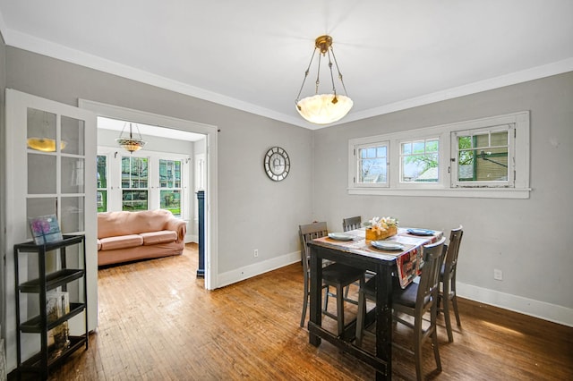 dining room with crown molding, baseboards, and hardwood / wood-style floors