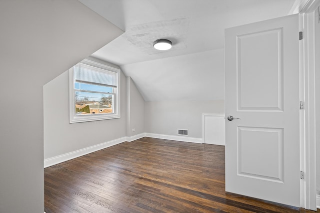 additional living space with lofted ceiling and dark hardwood / wood-style flooring