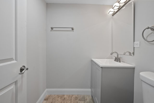 bathroom featuring vanity, toilet, and hardwood / wood-style floors