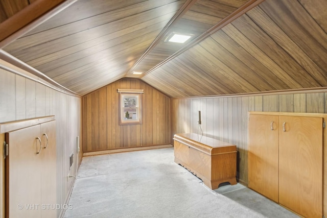 bonus room with wooden walls, vaulted ceiling, light carpet, and wooden ceiling