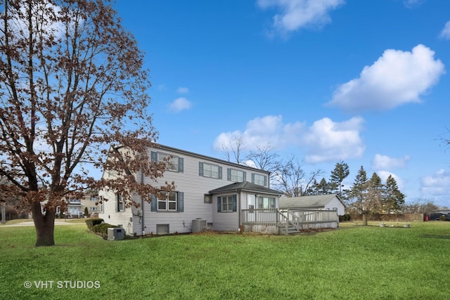 back of property featuring a wooden deck, a yard, and central AC unit