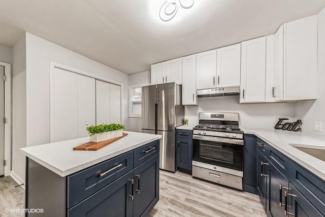 kitchen featuring white cabinetry, stainless steel appliances, light hardwood / wood-style floors, and blue cabinetry