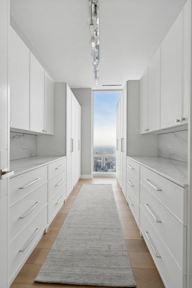 kitchen featuring a wall of windows, decorative backsplash, and white cabinets