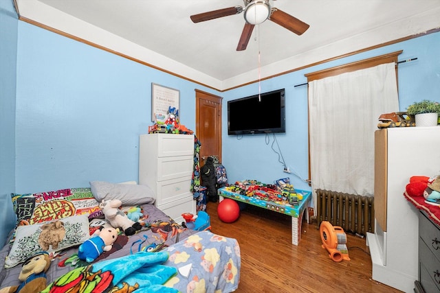 bedroom featuring ceiling fan, radiator, and hardwood / wood-style floors