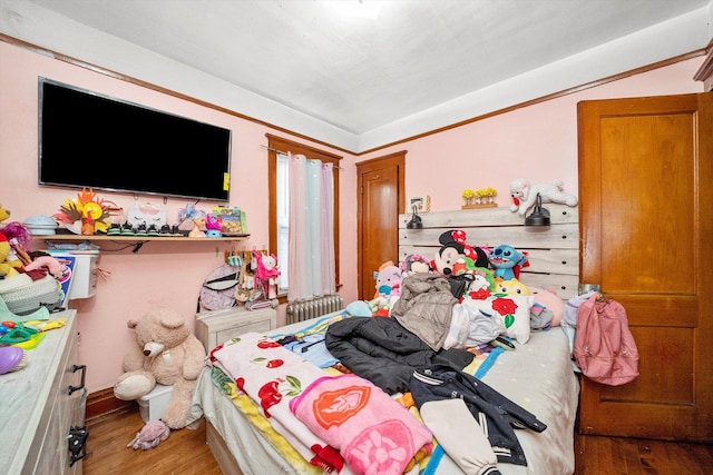 bedroom with radiator and wood-type flooring