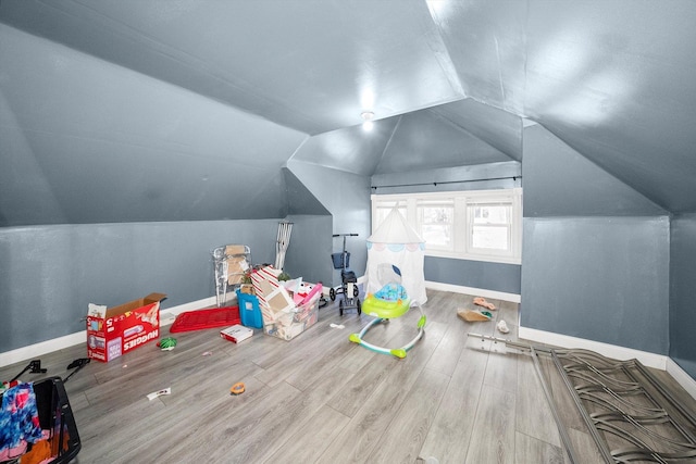 additional living space featuring lofted ceiling and hardwood / wood-style flooring