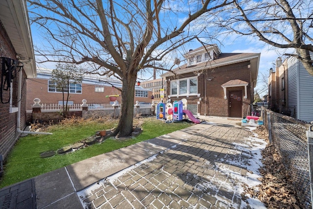 rear view of property featuring a playground